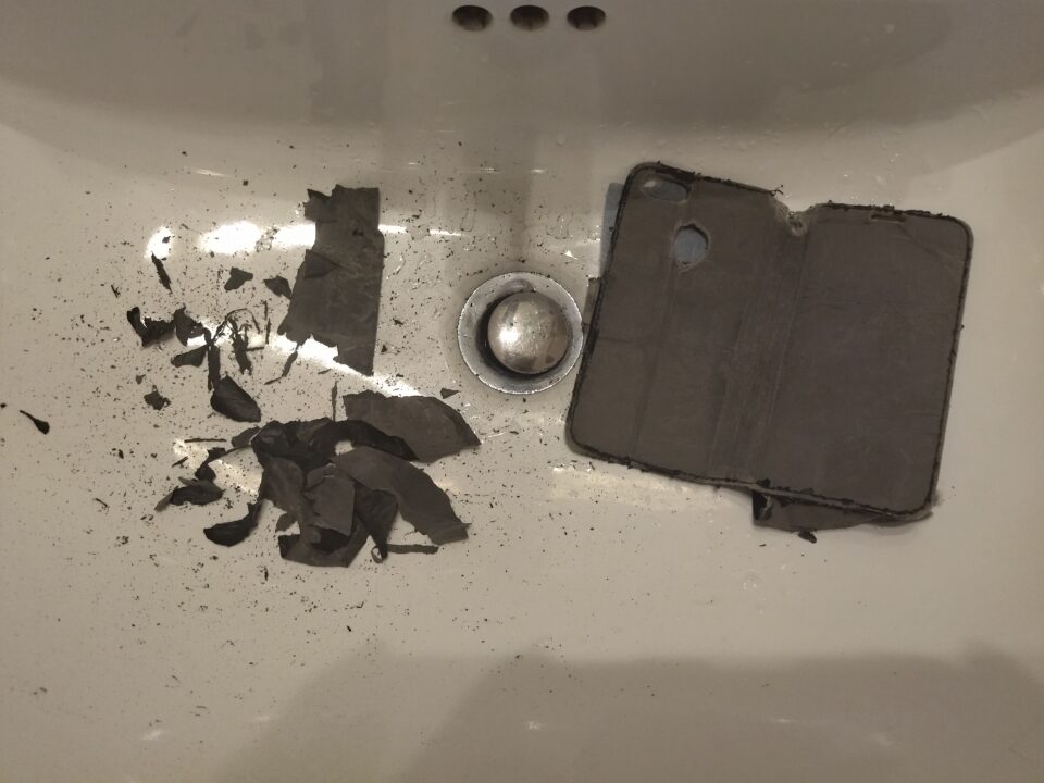 Particelle e frammenti grossi nel lavandino, e la cover buttata dentro, il retro tutto spellato.