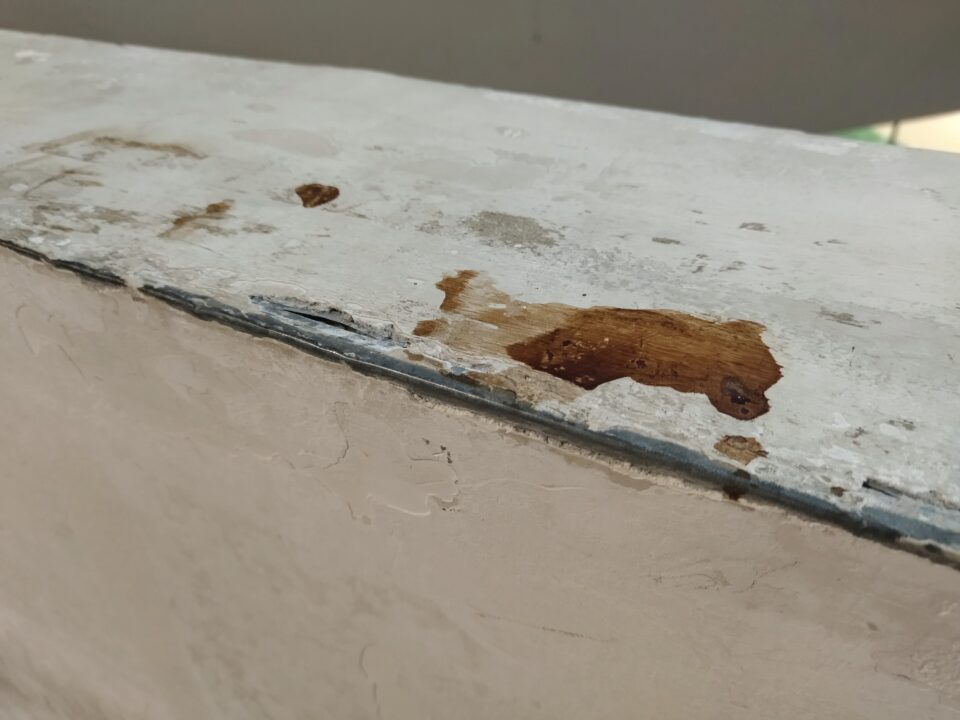 Foto di copertina, macchia di caffè polistratificata, anche se sembra fresca, su un muretto corrimano, con un po' di profondità di sfondo.